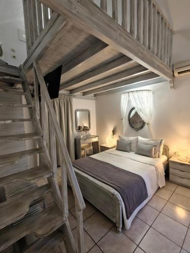 a bedroom with a large bed and a staircase at Kiklamino Sunset Suites in Oia