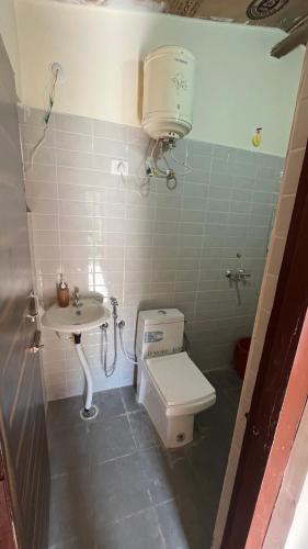 a small bathroom with a toilet and a sink at Luvyash Campsite Stays in Bhīm Tāl