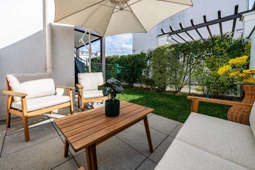 a patio with a table and chairs and an umbrella at Le Victoria Garden Disneyland Paris 10 pers in Serris