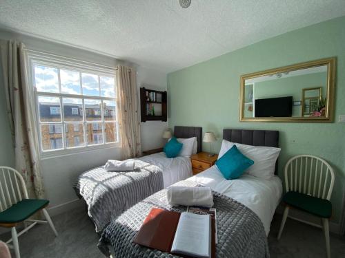 a hotel room with two beds and a mirror at Haddock Hideaway at The Whiteley in Scarborough