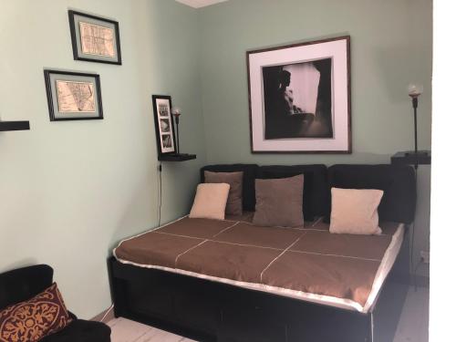 a bed in a room with pictures on the wall at Studio tout équipé, emplacement idéal in Saint-Raphaël