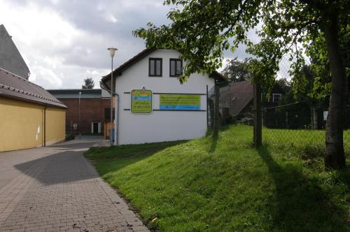a white building with a sign on the side of it at Fair Haven - Dobrej přístav in Lomnice nad Popelkou