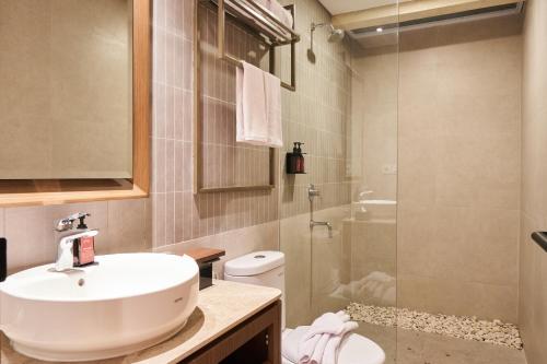 a bathroom with a sink and a toilet and a shower at Grand Luxcamp Pangandaran by Horison in Pangandaran