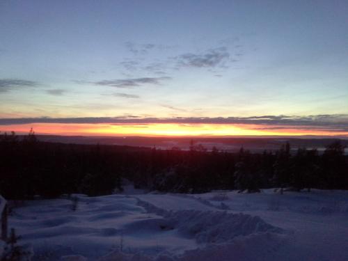 a sunset in the winter with snow on the ground at Karemajat Panorama hotel in Ylitornio
