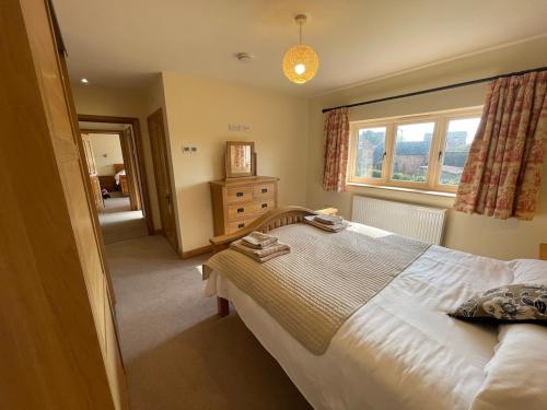 a bedroom with a large bed and a window at Stocks Lane Cottage in Welshampton