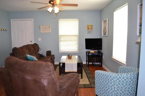 a living room with two chairs and a ceiling fan at Casa Carmen home in Crystal Beach