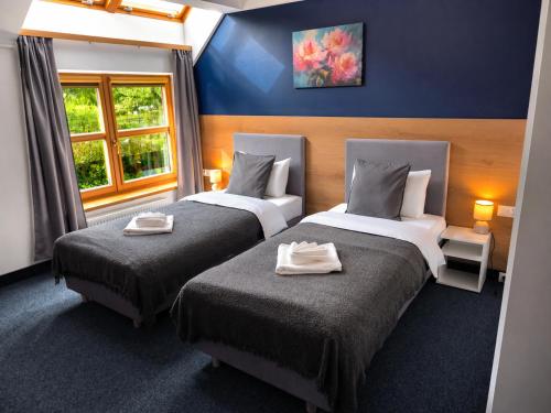 a bedroom with two beds with towels on them at Dom Oliwski in Gdańsk