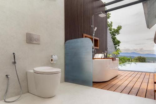 a bathroom with a bath tub and a toilet and a bath tub at Andriyala in Haputale