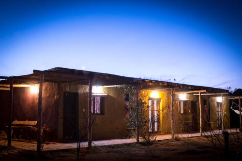 a house with lights on the side of it at night at Chakana Hospedaje Rural in Villa Unión