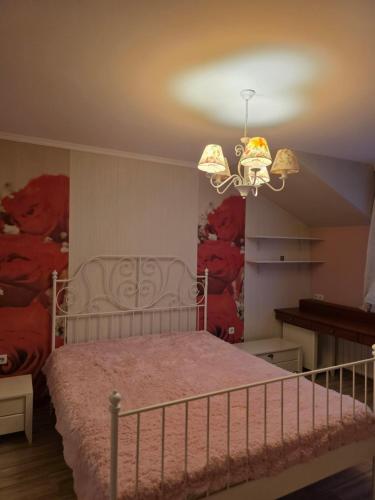 a bedroom with a bed and a chandelier at Boutique Apartment with Jacuzzi Pleven in Pleven