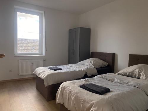 a bedroom with two beds and a window at Stefans Apartments B - 20 min bis DD Messe und Flughafen inkl Parkplatz in Willich