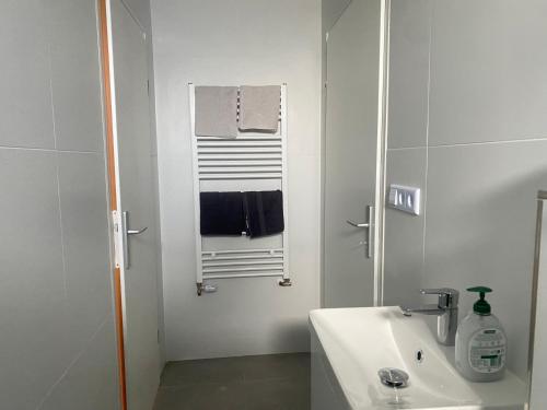 a white bathroom with a sink and a mirror at Stefans Apartments B - 20 min bis DD Messe und Flughafen inkl Parkplatz in Willich