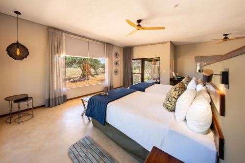 a bedroom with a large bed and a window at Okonjima Plains Camp in Otjiwarongo