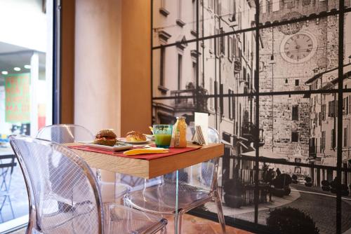 a table with chairs and a plate of food on it at Locanda delle Mercanzie in Brescia