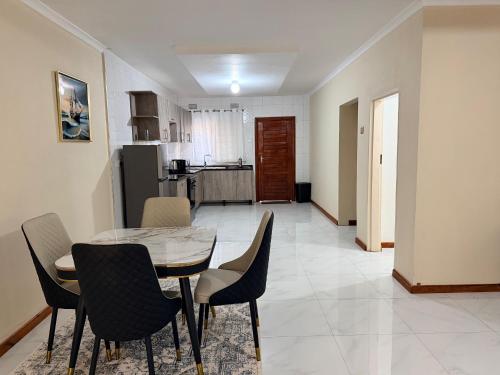 a kitchen and dining room with a table and chairs at Destiny Executive Apartments in Solwezi