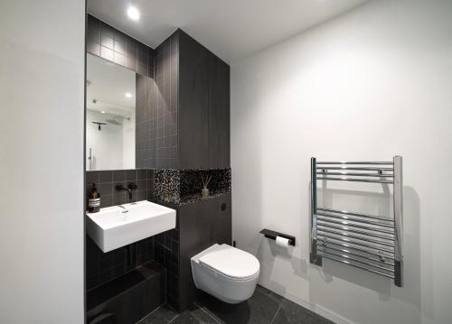 a bathroom with a white toilet and a sink at 02 Arena, Specious Apartments in London