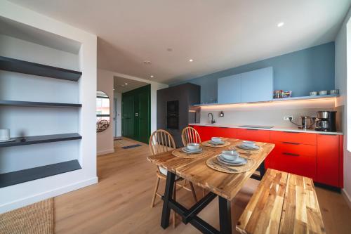 a kitchen with a wooden table and red cabinets at 02 Arena, Specious Apartments in London