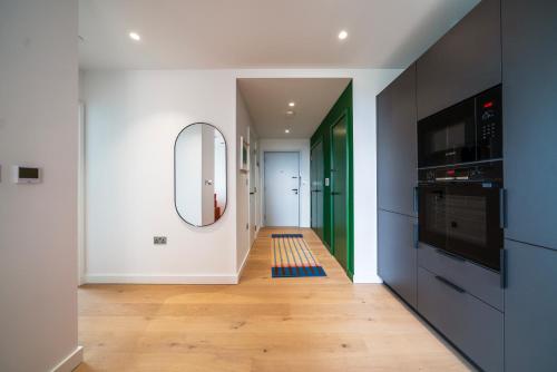 a hallway with a large mirror and a kitchen at 02 Arena, Specious Apartments in London