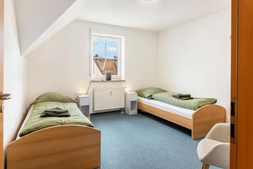 two beds in a room with a window at Komfortable 3-Zimmer-Fewo in Sonneberg