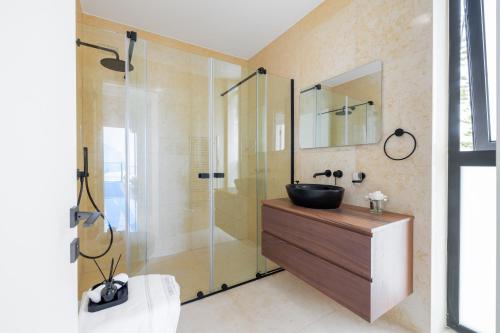a bathroom with a sink and a glass shower at MITO Seaview by Serbellas in Kissonerga