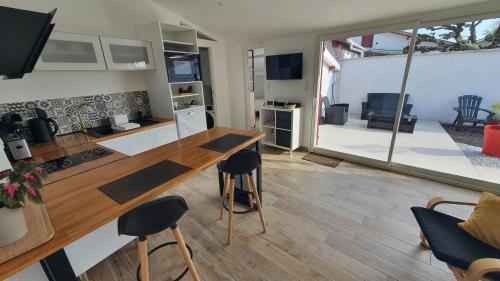 a kitchen and living room with a table and chairs at La Parent'aise in Parentis-en-Born