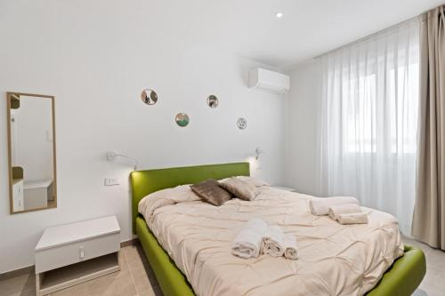 a bedroom with a large bed with a green headboard at La Pulvarera in Castelsardo
