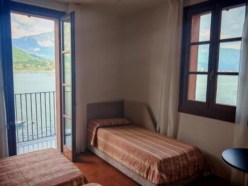 a room with two beds and a window with a view at Hotel Bellavista Valmadrera in Valmadrera