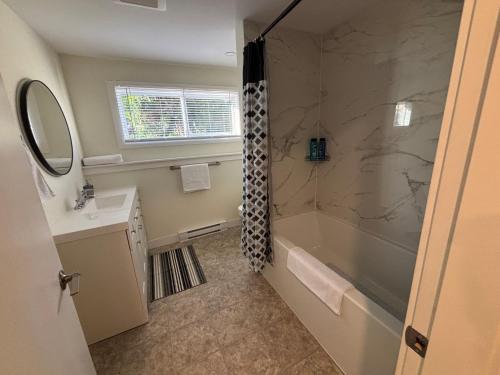 a bathroom with a shower and a tub and a sink at Private Guest Suite In Colwood in Colwood