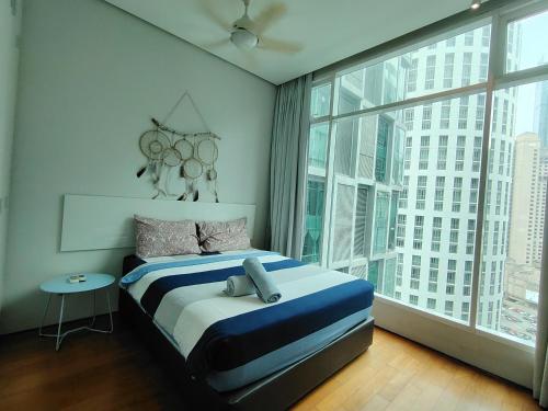 a bedroom with a bed and a large window at Soho Suites Kualalampur by homestay klcc in Kuala Lumpur