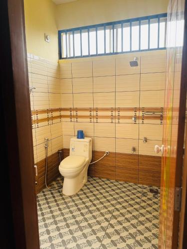 a bathroom with a toilet in a room at Rivera Holidays in Vythiri