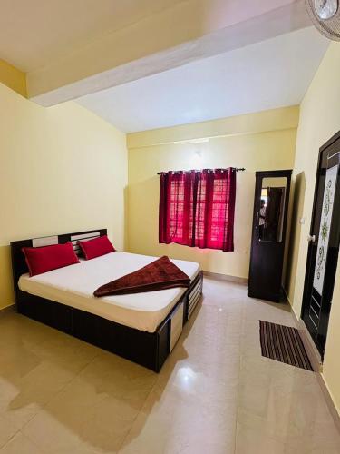a bedroom with a bed and a red window at Rivera Holidays in Vythiri