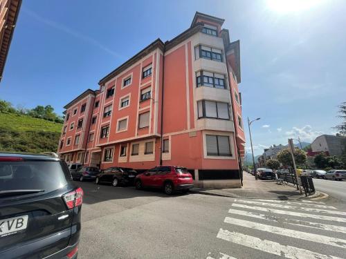 a red car parked in front of a building at Amplio Loft con plaza de garaje in Cangas de Onís