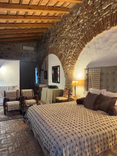a bedroom with a large bed and a stone wall at Can Carbó de Peralada in Peralada