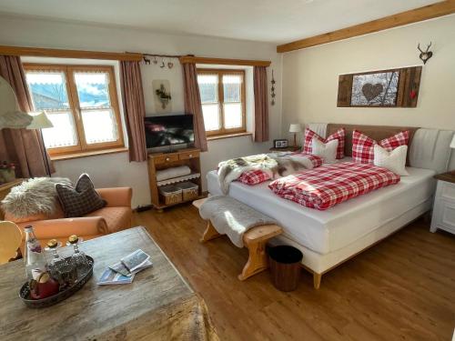 a living room with a bed and a couch at Pension Marianne - Chiemgau Karte in Inzell