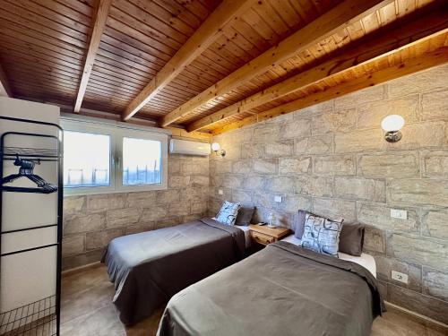 two beds in a room with a stone wall at Bungalow Atlantic View in Maspalomas