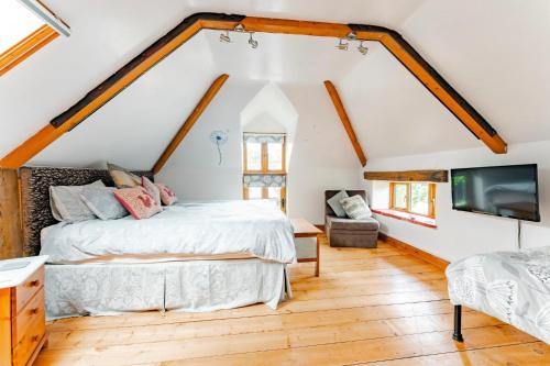 a bedroom with a bed and a tv at Roundabout Farm in Thurning