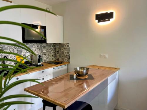 a kitchen with a wooden table and a plant at Cocoon Studio Ciel de Fabron in Nice