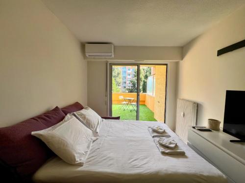 a bedroom with a bed and a sliding glass door at Cocoon Studio Ciel de Fabron in Nice