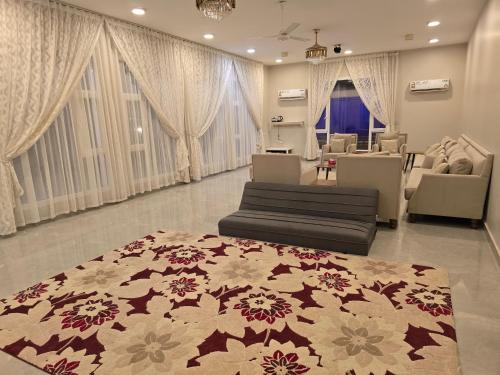 a living room with two couches and a rug at Katara Garden in As Suwayq