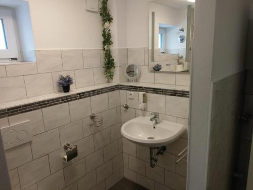 a white bathroom with a sink and a mirror at NEU! Ferienwohnung am Ahlberg in Toppenstedt