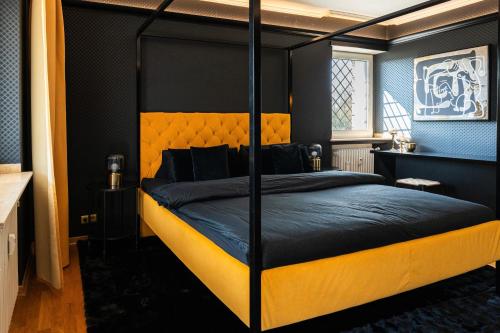 a bedroom with a bed with a black and yellow bed frame at Zur Herrlichkeit in Warendorf