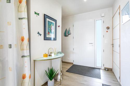 a white hallway with a table and a door at Chambre d'hôtes Marine in Binic