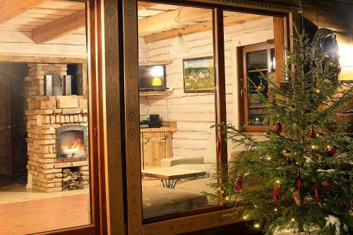 a living room with a christmas tree and a fireplace at Dabintos slėnis in Sumiliszki