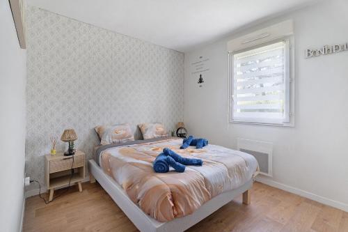 a bedroom with a bed with blue pillows on it at Le Cocon De Laurence in Pleurtuit