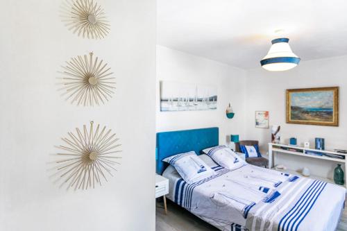 a bedroom with a bed and two sunburst clocks on the wall at Chambre d'hôtes Marine in Binic