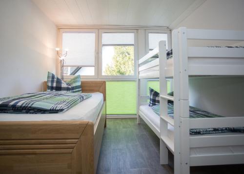 a bedroom with two bunk beds and a window at Haus Jungmann in Hallenberg