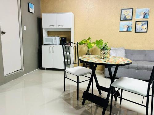 a living room with a table and a couch at Suite Antiguo in Antiguo Cuscatlán