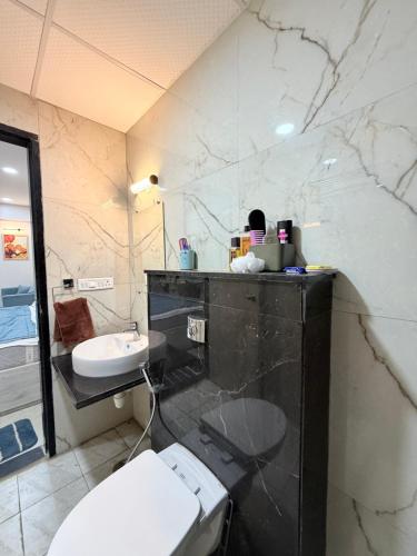 a bathroom with a white toilet and a sink at The Sakshi suite - Luxury Saty with Premium Comfort in Jaipur