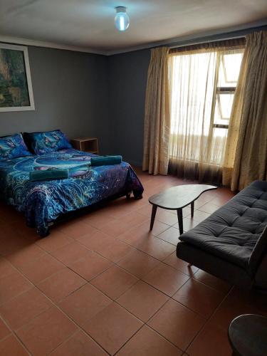 a bedroom with a bed and a table and a couch at Cozy Corner Serenity Suite in Bredasdorp
