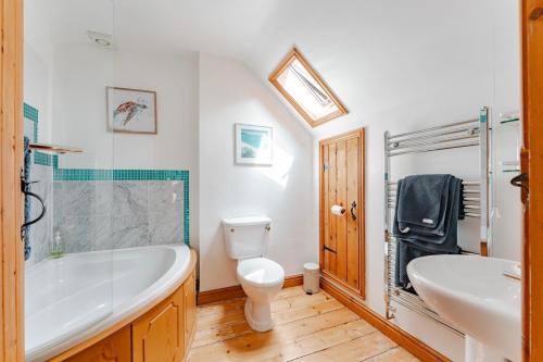 a bathroom with a tub and a toilet and a sink at Roundabout Farm in Thurning